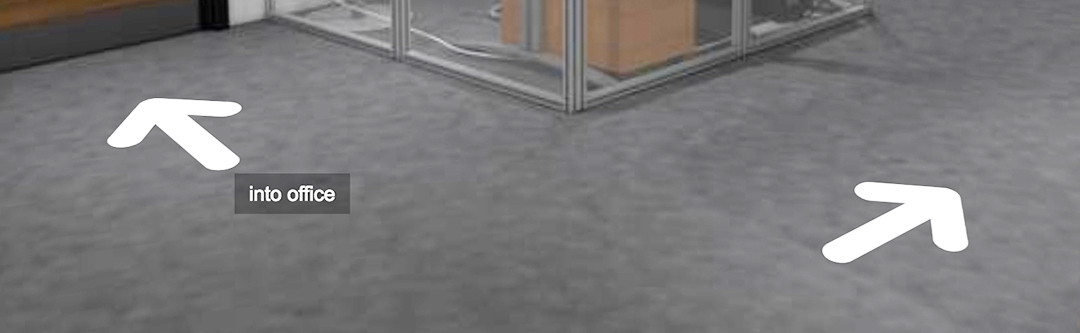 Walk through the office by clicking on the white arrows on the floor.
